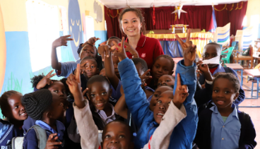Photo of Canadian female smiling with students in Zambia